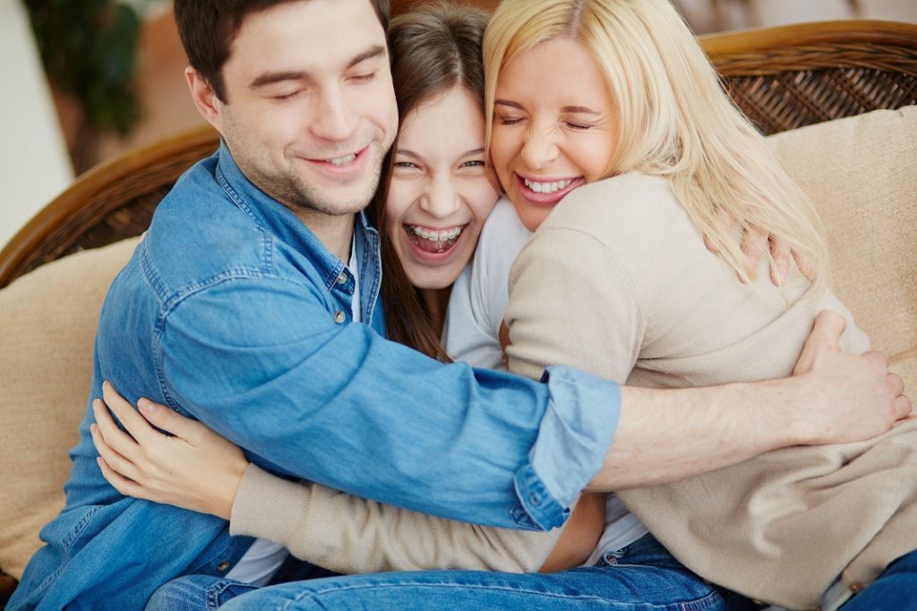 Portrait of happy family of three embracing